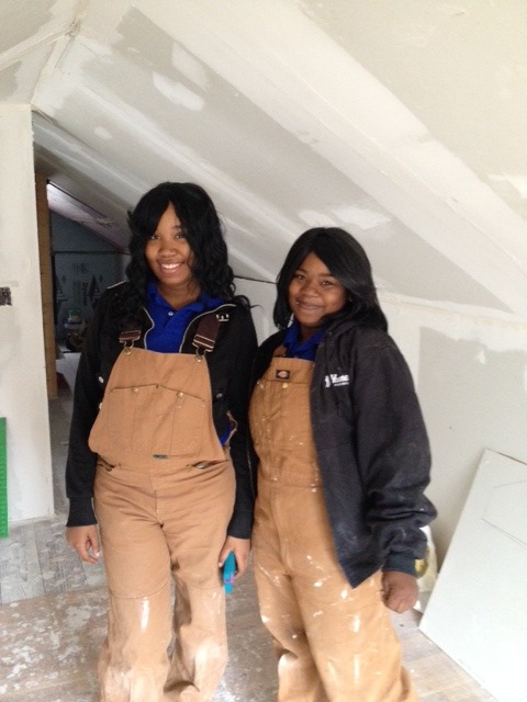 Two woman wearing workers overalls
