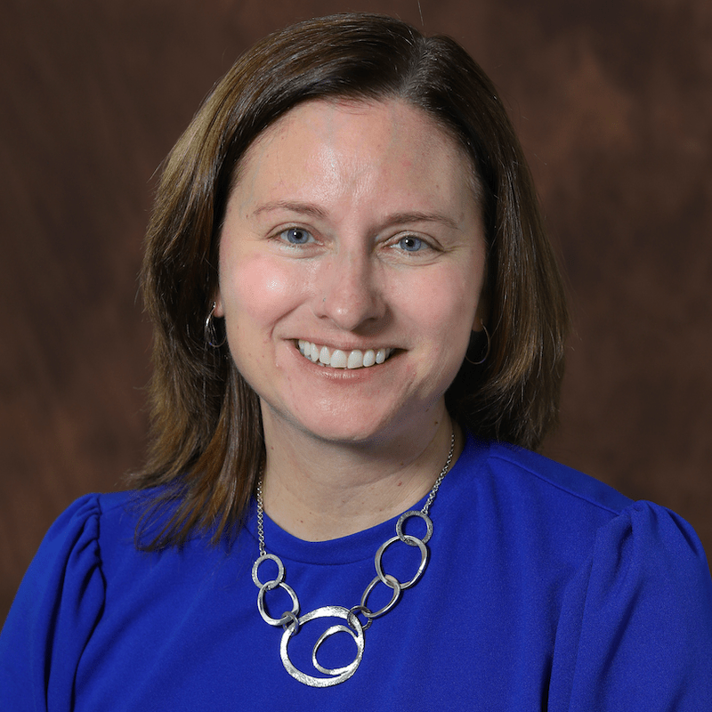 Portrait of Dan smiling with blue background